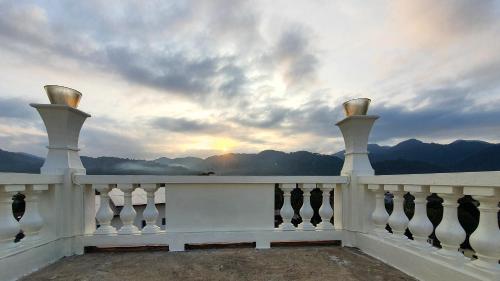 a white fence with a view of the mountains at Daddy Dream Hotel and Residence in Ranong