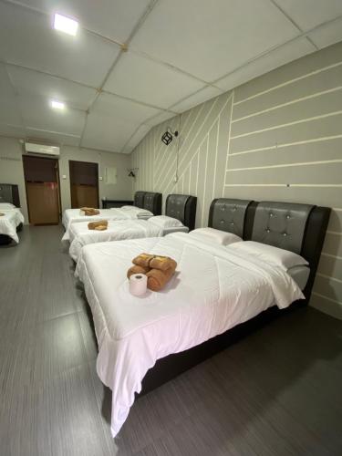 una fila de camas alineadas en una habitación en Julies Hostel Taman Negara, en Kuala Tahan