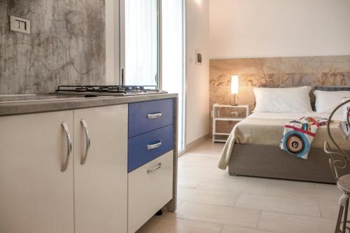 a kitchen with a sink and a bed in a room at La Maison Blue Salento - Villetta e monolocale fronte e vista mare in Torre San Giovanni Ugento