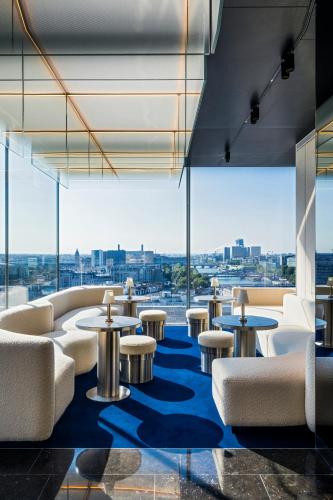 a lobby with tables and chairs and a view of the city at SO/ Paris Hotel in Paris