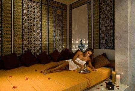 a woman sitting on a bed in a room at Yadis Hammamet in Hammamet