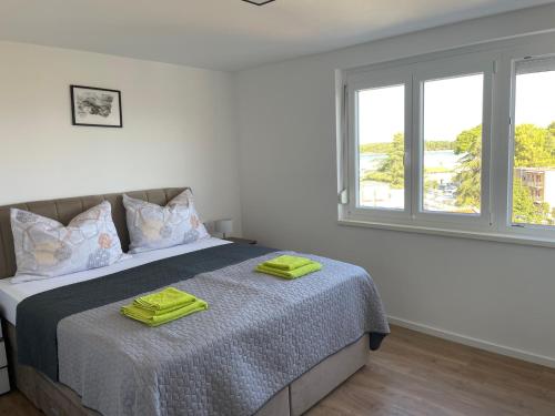1 dormitorio con 1 cama con toallas verdes en APP Robi en Novigrad Istria