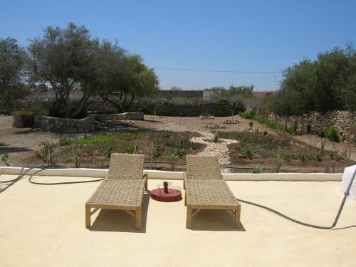 two chairs and a fire hydrant on a patio at RIAD ACACIA in Essaouira
