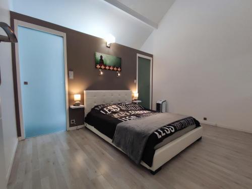 a bedroom with a large bed and a sliding glass door at Duplex Autonome Cosy à Paris Roissy CDG in Roissy-en-France