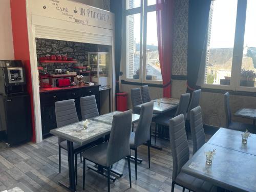 a dining room with tables and chairs and windows at Hotel Au Chapon Fin in Poitiers