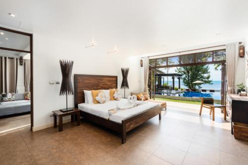 The Emerald Hill Beach Villa في شاطئ مينام: غرفة نوم بسرير ونافذة كبيرة