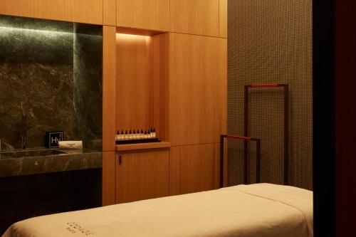 a small bedroom with a bed and a sink at SO/ Paris Hotel in Paris