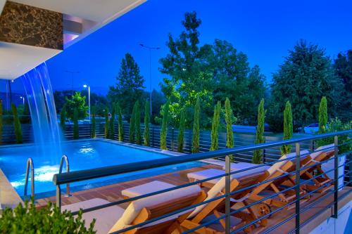 a deck with chairs and a swimming pool at night at Selin Luxury Residences in Ioannina