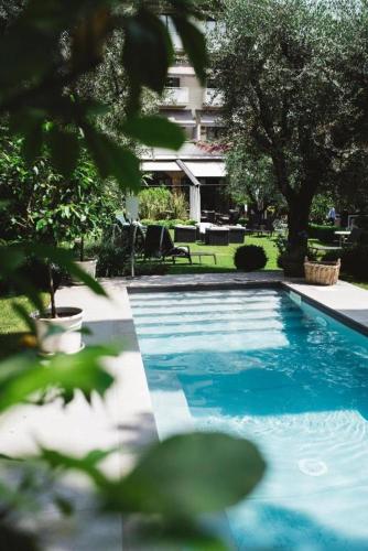 a blue swimming pool in front of a building at Hotel Piccola Vela in Desenzano del Garda