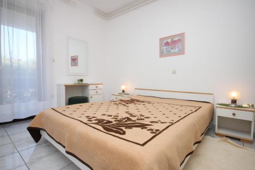 a bedroom with a large bed and a window at Apartments by the sea Novalja, Pag - 3307 in Novalja