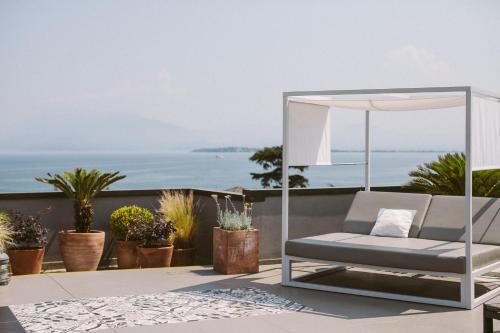 a chair on a balcony with a view of the ocean at Hotel Piccola Vela in Desenzano del Garda