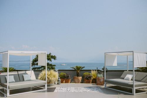 a patio with two chairs and a view of the ocean at Hotel Piccola Vela in Desenzano del Garda