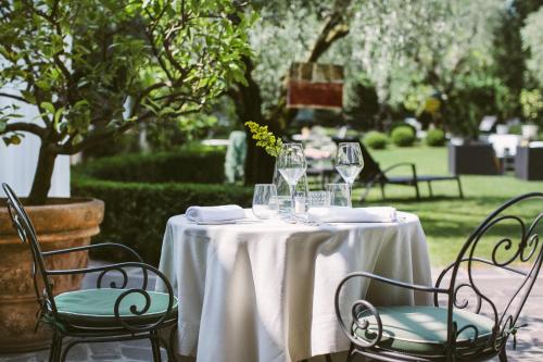 a table with a white table cloth and wine glasses at Hotel Piccola Vela in Desenzano del Garda