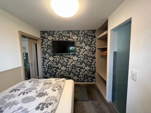a bedroom with a bed and a tv on a wall at Apartment Siegfried in Bayreuth