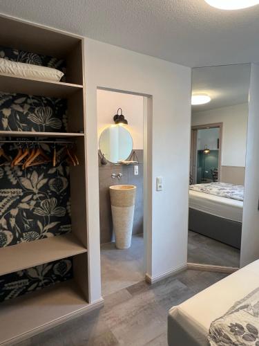 a bedroom with a bed and a bathroom with a mirror at Apartment Siegfried in Bayreuth