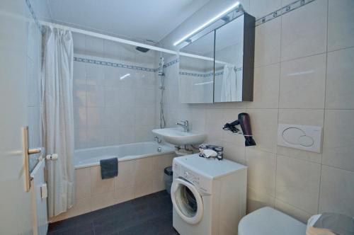 La salle de bains est pourvue d'un lave-linge et d'un lavabo. dans l'établissement Haus Viktoria A, Apartment Stockhorn, à Zermatt