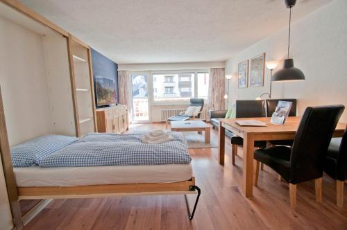 - une chambre avec un lit, un bureau et une table avec des chaises dans l'établissement Haus Viktoria A, Apartment Stockhorn, à Zermatt