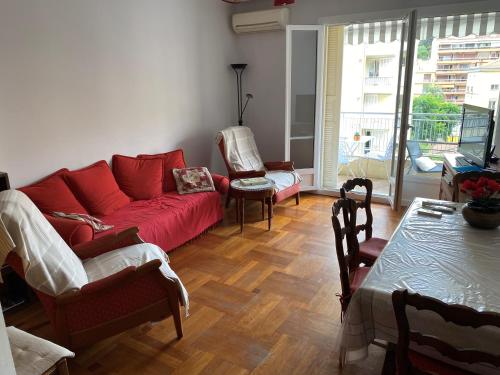 a living room with a red couch and a table at Le Minerve in Menton