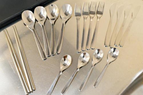 a group of silver spoons and forks on a tray at だるまマンション901 in Naha