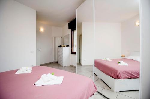 a bedroom with a pink bed and a mirror at InnPisaRentals - Charme Pisa Toscana 2 in Pisa