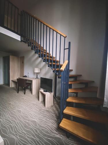 a staircase in a room with a desk and a table at Hotel Hafenresidenz Stralsund in Stralsund