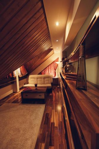 a living room with a white couch and wooden floors at Denisa Boutique in Poiana Brasov
