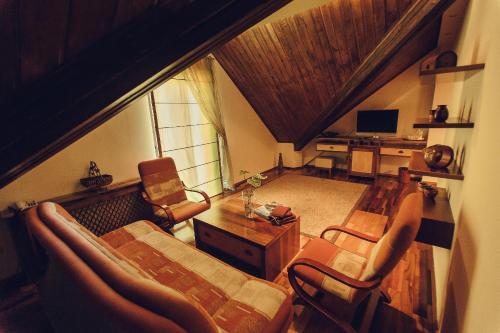 a living room with a couch and chairs and a television at Denisa Boutique in Poiana Brasov