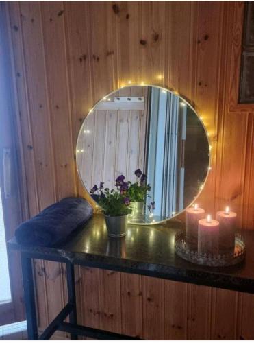 un espejo en la parte superior de un mostrador con velas en Hietman vierastalon sininen huone, 