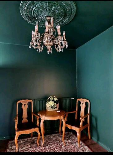 une salle à manger avec une table, deux chaises et un lustre dans l'établissement Hietman vierastalon sininen huone, 