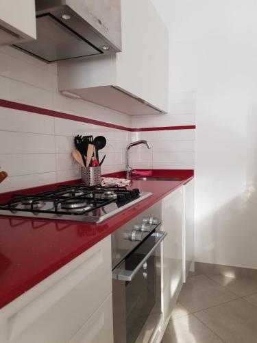 a kitchen with a stove and a red counter top at APPARTAMENTO CALETTA 2 in Castiglioncello