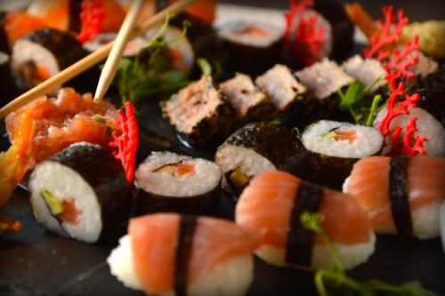 a bunch of sushi sitting on a plate with chopsticks at Hotel Antines in La Villa