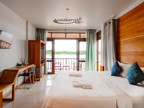 1 dormitorio con cama, escritorio y ventana en Norn Nab Dao Rimkhong, en Chiang Khan