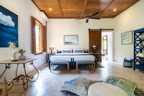 a bedroom with a bed and a table at Villa Pulau Cinta Boutique Suites in Gili Meno