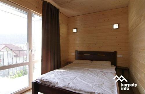 - une chambre avec un lit et une grande fenêtre dans l'établissement Гірка, à Skole