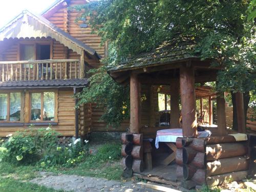 a log cabin with a bed in front of it at Oselia Lada in Tukhlya