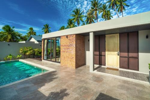 a house with a swimming pool next to a building at Thai Fight Hotel in Lamai