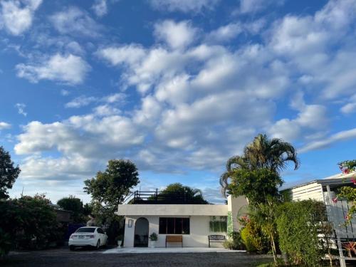 a house with a palm tree and a cloudy sky at นอนนี่แอทเขาค้อ in Khao Kho