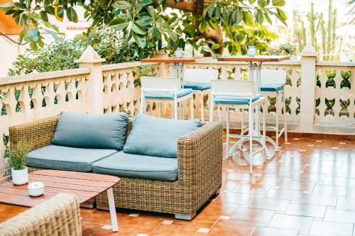 a patio with a couch and tables and chairs at 4U Miranda - Adults Only in Santa Ponsa