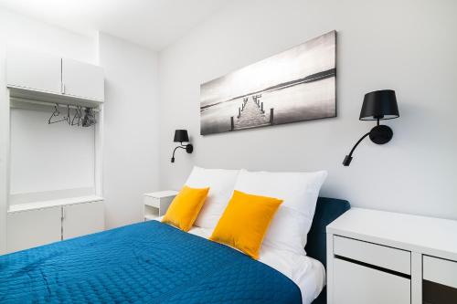 a bedroom with a blue bed with yellow pillows at Easy Rent Apartments - Kosmos, 24h Check-in in Lublin