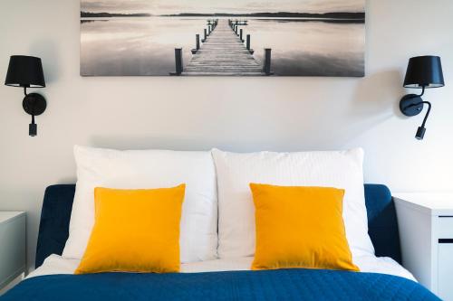 a bedroom with a bed with two yellow pillows at Easy Rent Apartments - Kosmos, 24h Check-in in Lublin