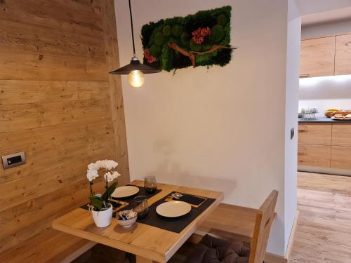La Culla B&B في بادولا: طاولة غرفة الطعام مع الأطباق والزهور عليها