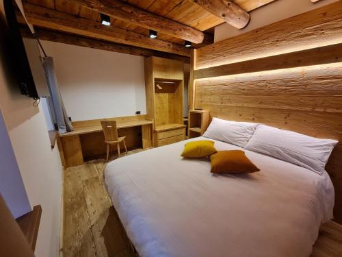 a bedroom with a white bed with two yellow pillows at La Culla B&B in Padola