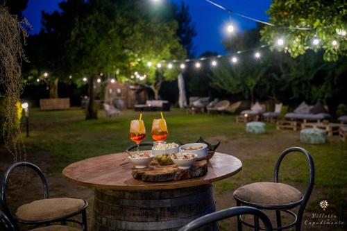 - une table avec deux verres de vin et des bols de nourriture dans l'établissement Villetta Capodimonte, à Naples