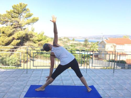 une femme faisant une pose de yoga sur un tapis de yoga dans l'établissement Despina Studios and Apartments, à Lassi