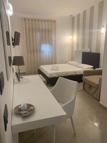 a room with two beds and a table and chairs at Cala di Ponente in Castelluzzo