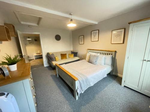 a bedroom with a bed and a couch at Westend Holiday Let 2 Brecon in Brecon