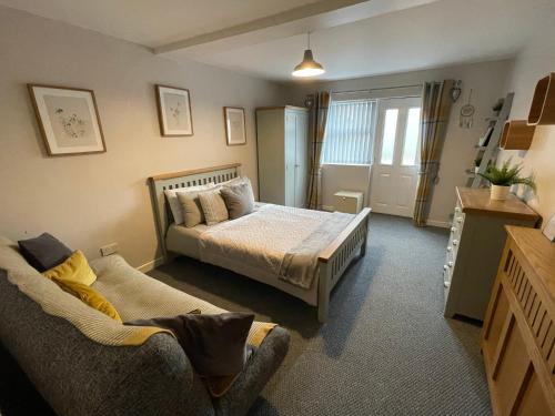 a bedroom with a bed and a couch in it at Westend Holiday Let 2 Brecon in Brecon