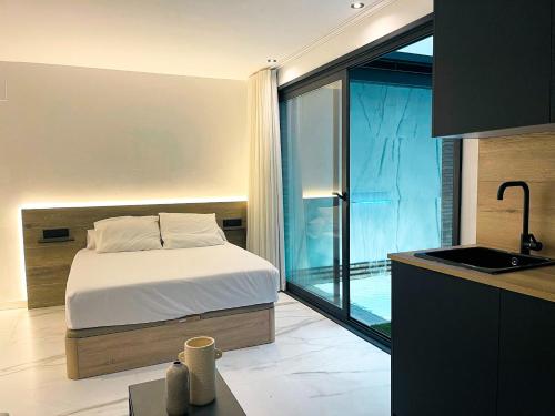 a bedroom with a bed and a kitchen with a window at CORDOBA BOUTIQUE vv in Córdoba