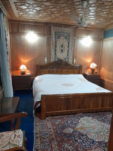 1 dormitorio con 1 cama grande de madera y 2 lámparas en Palace Heights en Srinagar