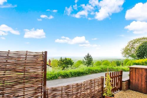 a wooden fence in front of a road at Romantic & Cosy Cottage with Direct Access to the Hills in Malvern Wells